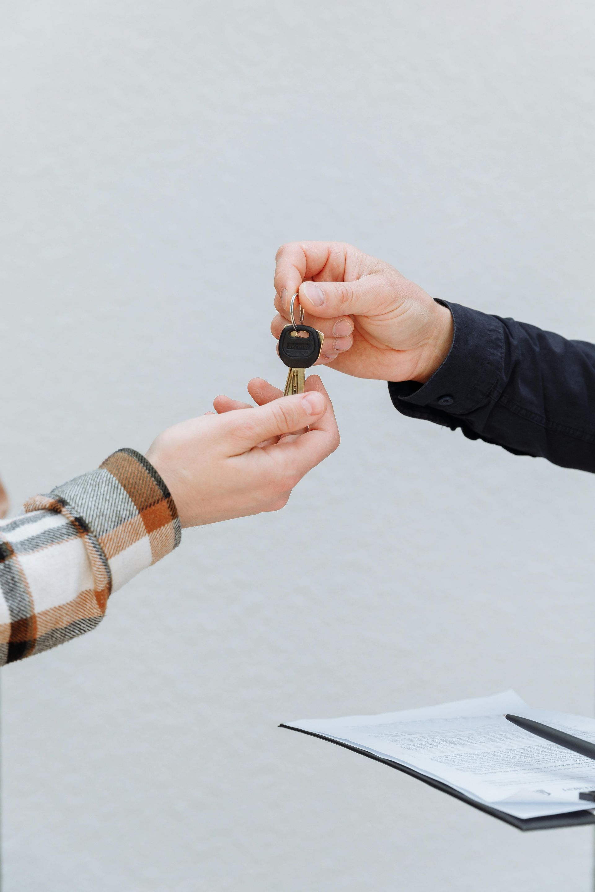 A man is giving keys to his daughter in a car showroom.