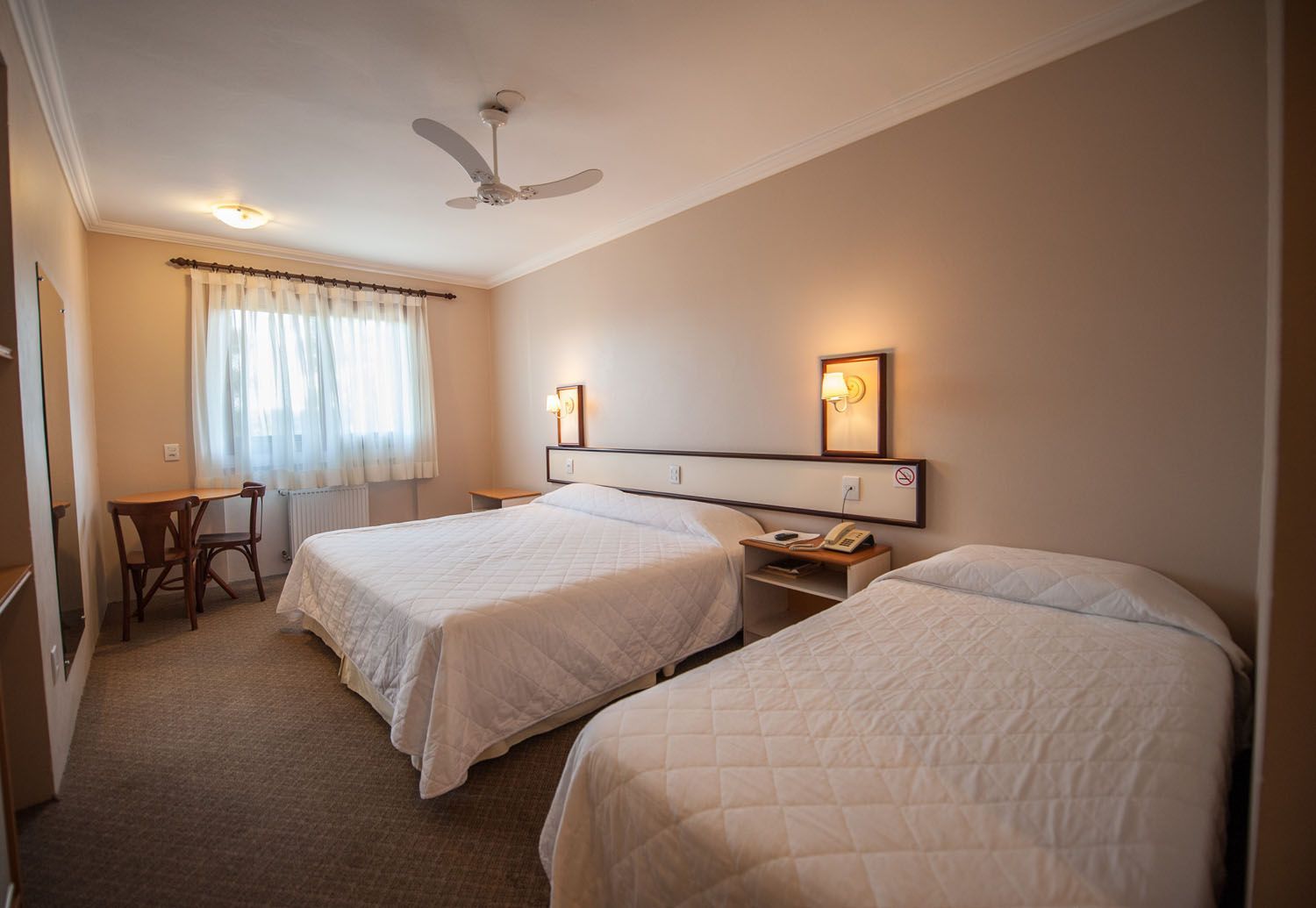 um quarto de hotel com duas camas e ventilador de teto