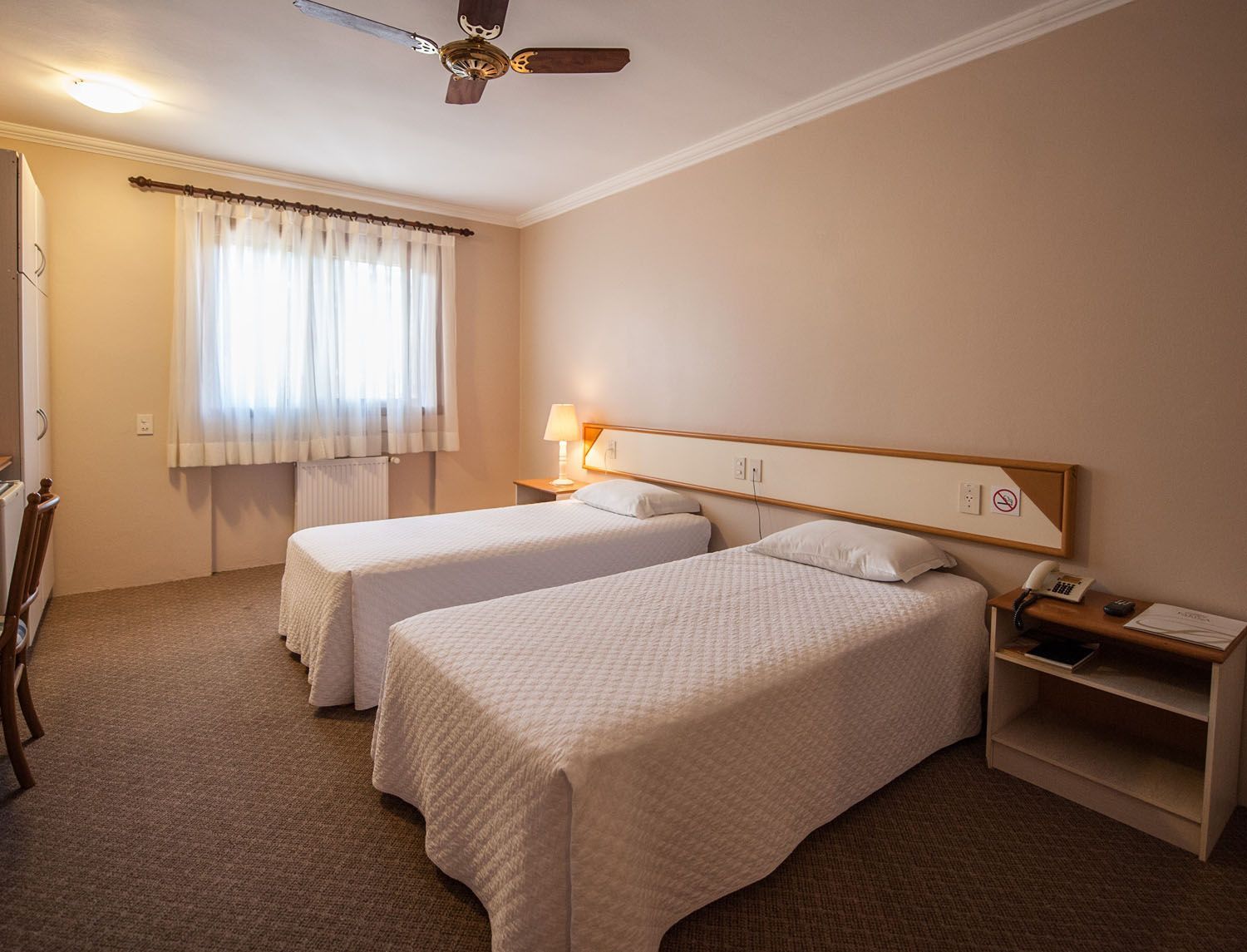 um quarto de hotel com duas camas e ventilador de teto