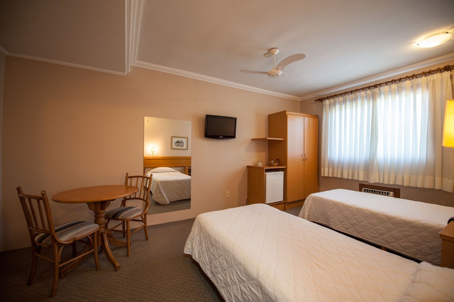 um quarto de hotel com duas camas, mesa e cadeiras.