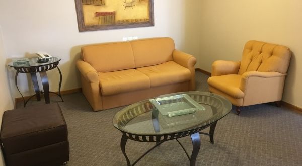 uma sala de estar com sofá, cadeira e mesa de centro