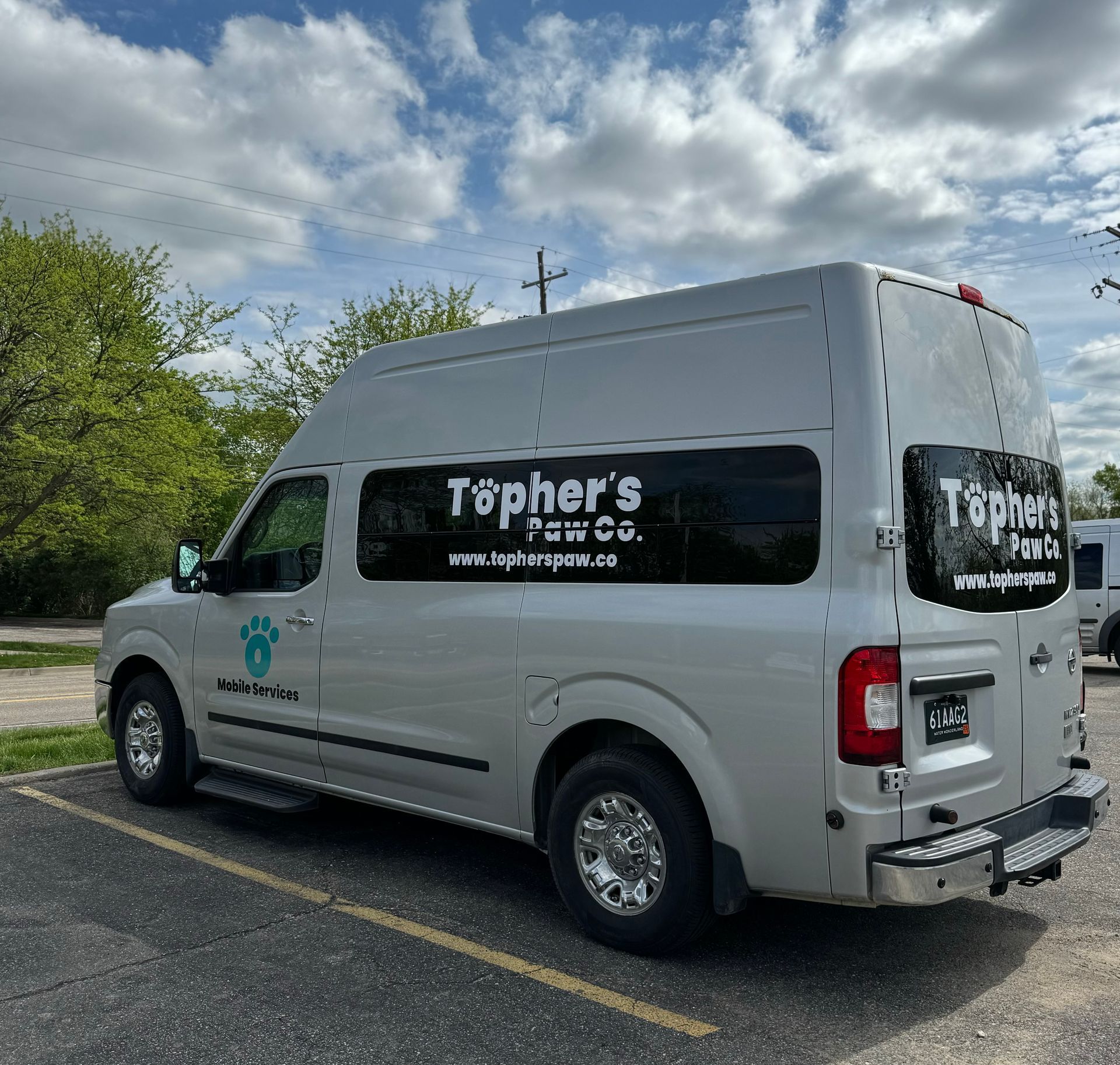 A white van with the word tophers on the side is parked in a parking lot.
