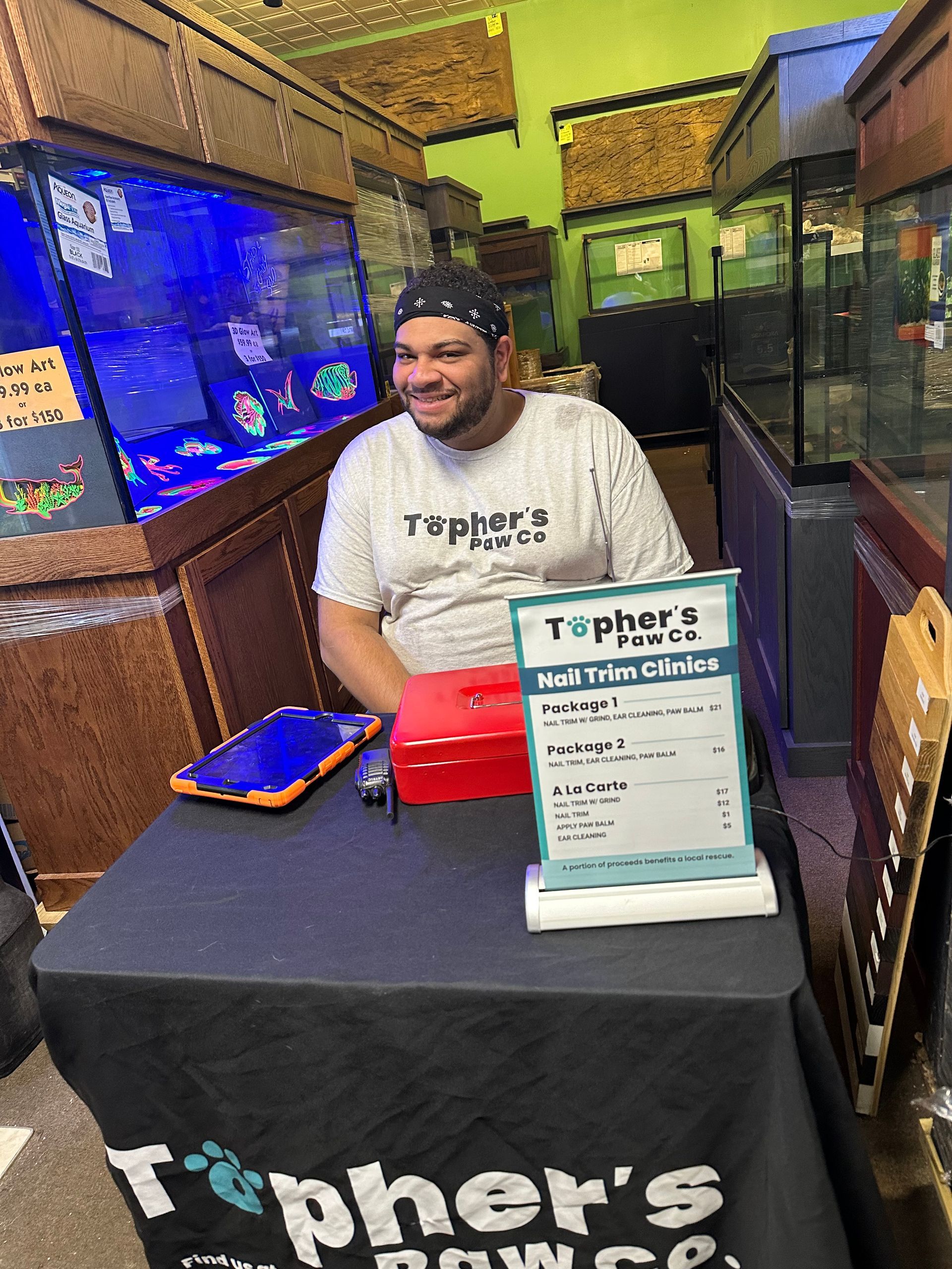 A man is sitting at a table in front of an aquarium.