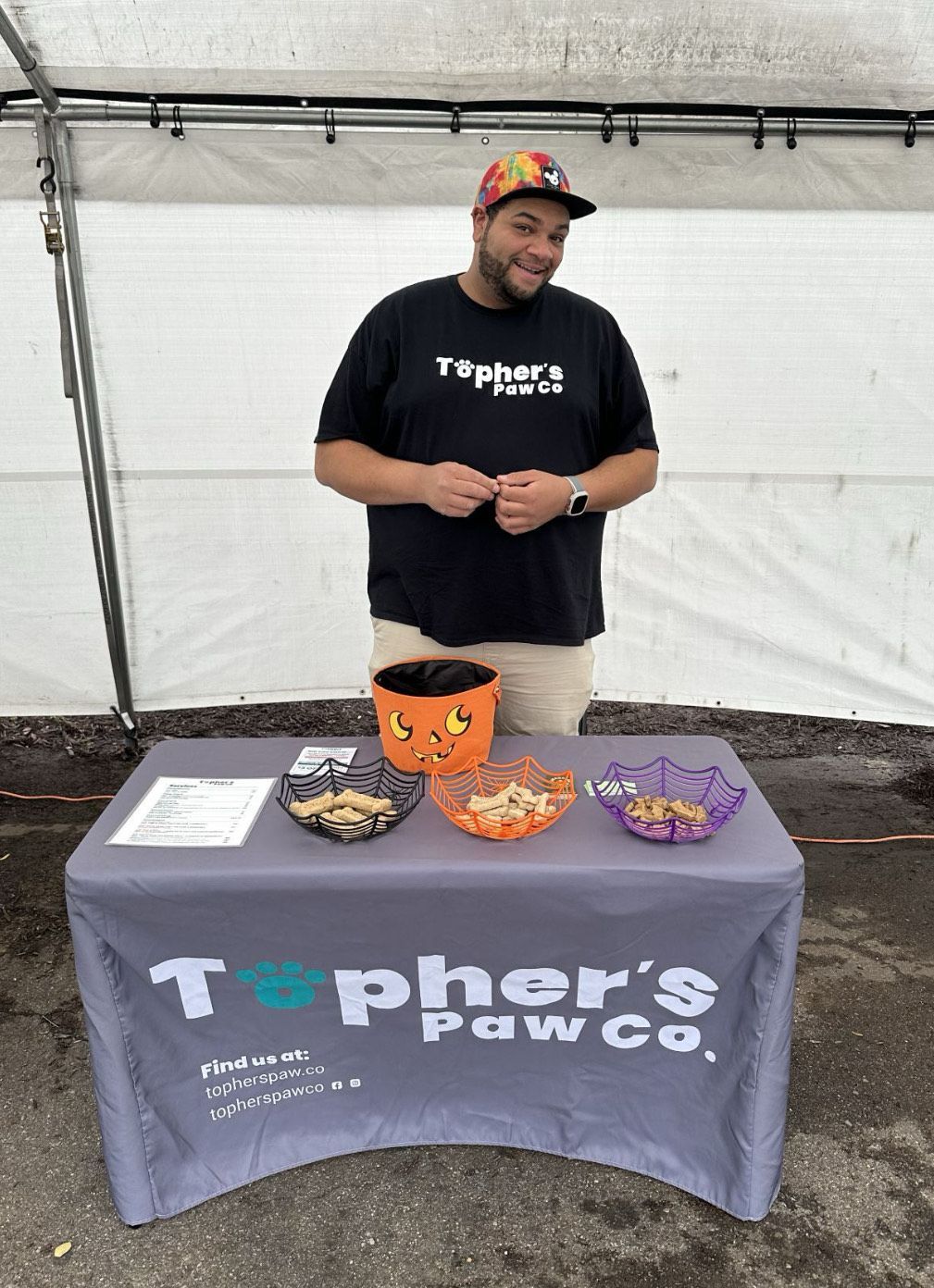 A man is standing in front of a table with bowls of food on it.