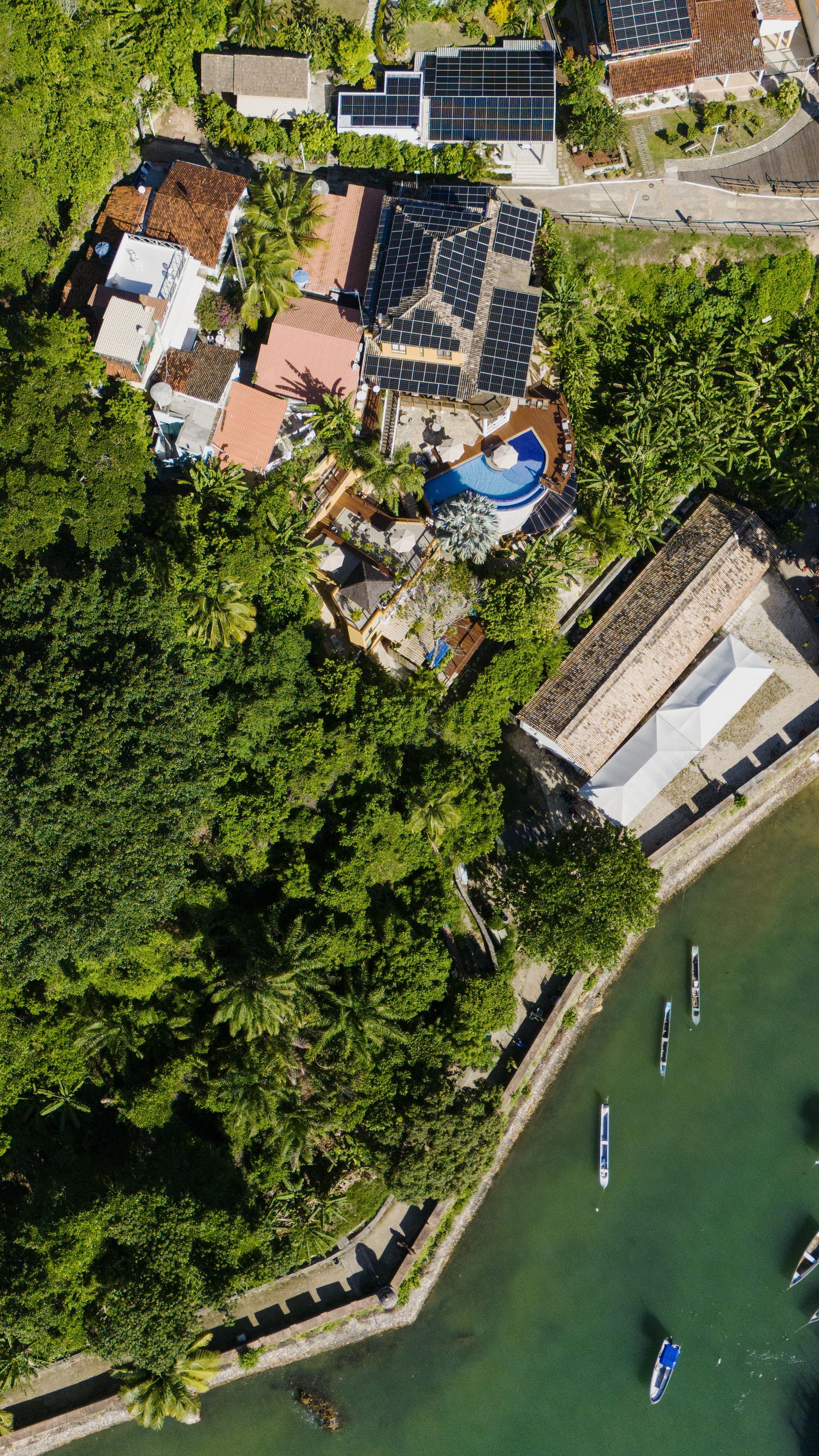 Uma vista aérea de uma praia com muitas árvores e edifícios. - Pousada Pasargada