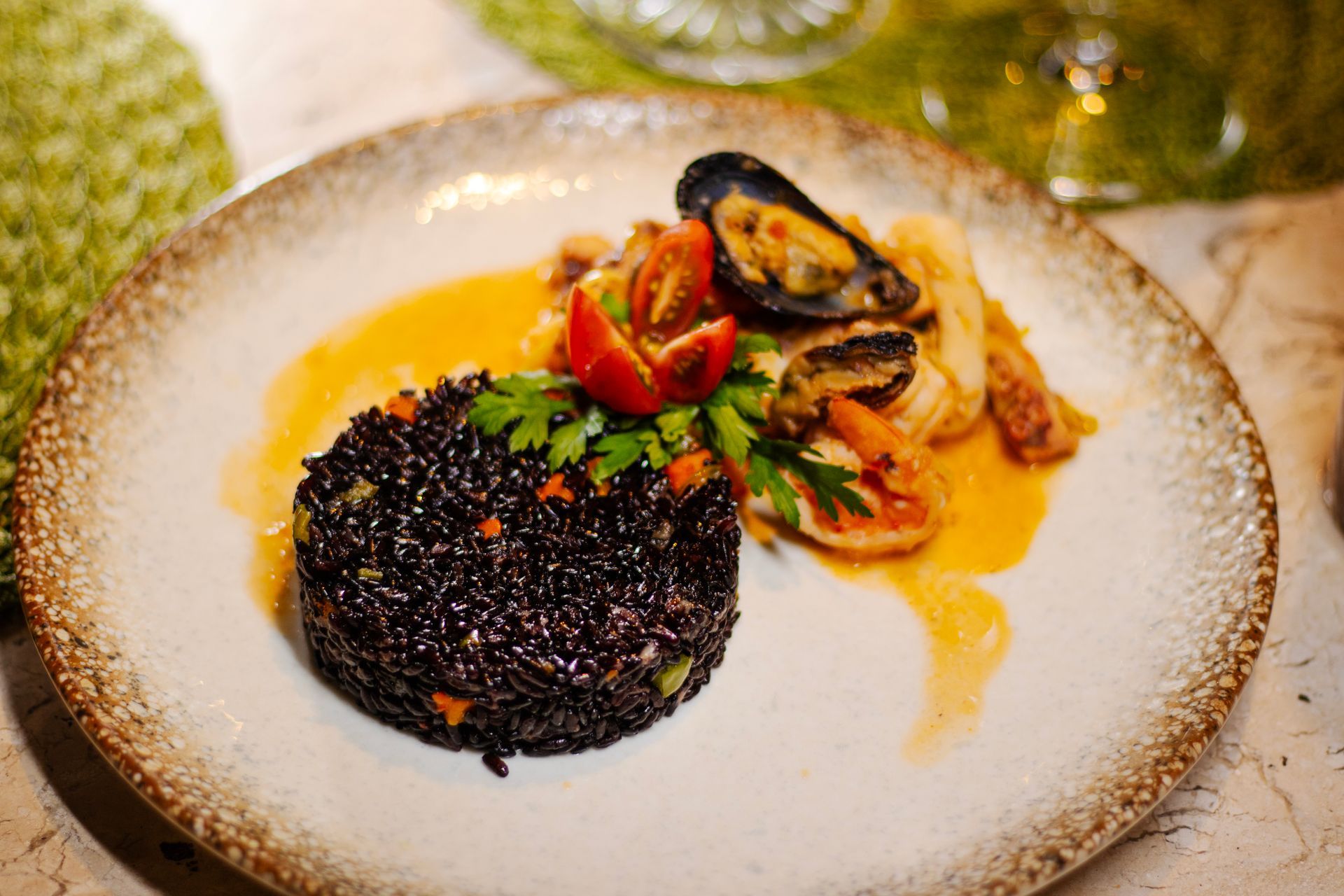 Um prato de comida com arroz e frutos do mar em uma mesa. - Pousada Pasargada