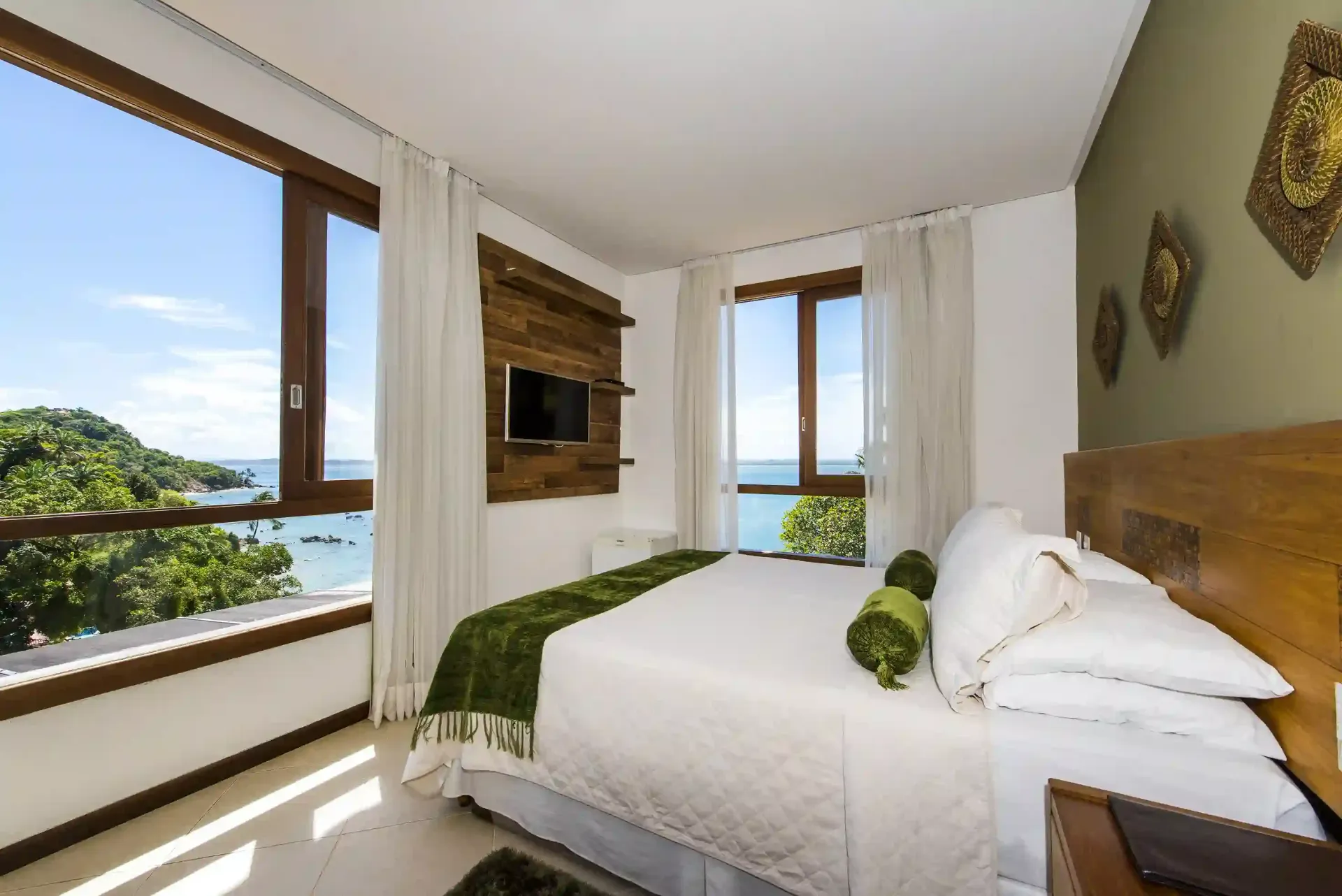 Um quarto com uma cama grande e uma televisão na parede. - Pousada Pasargada