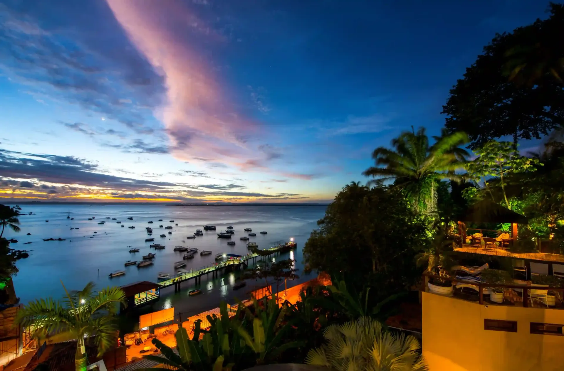 Uma vista aérea de uma grande piscina cercada por guarda-sóis e cadeiras. - Pousada Pasargada