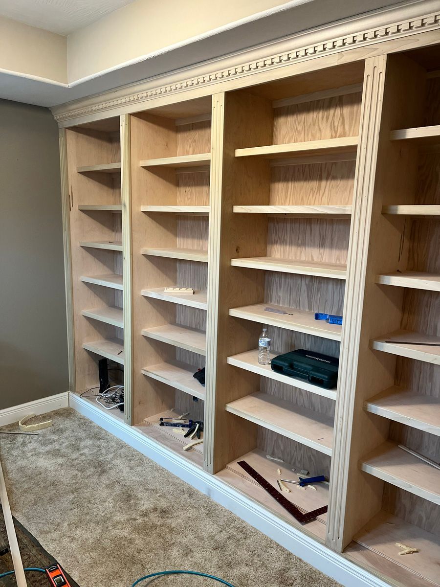A room with a lot of shelves and a carpeted floor.