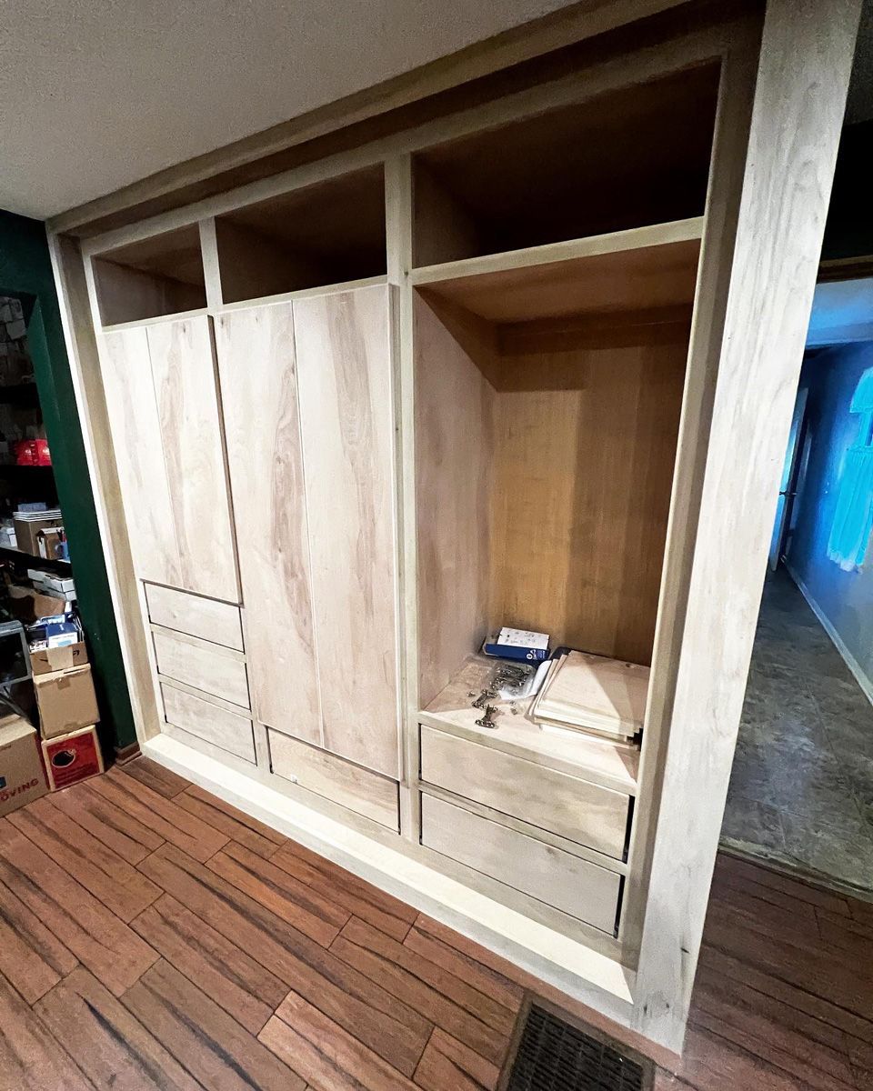 A large closet with wooden doors and drawers in a room.
