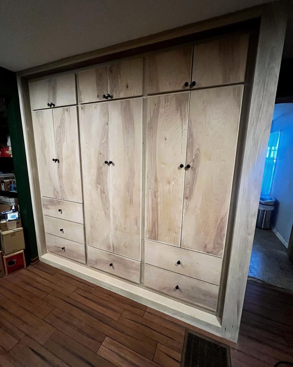 A large wooden cabinet with drawers and doors in a room.