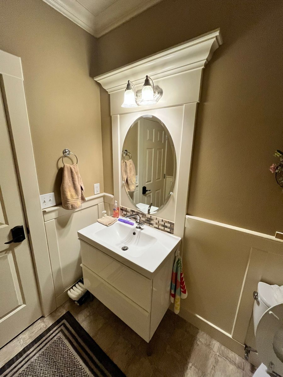 A bathroom with a sink , mirror and toilet.