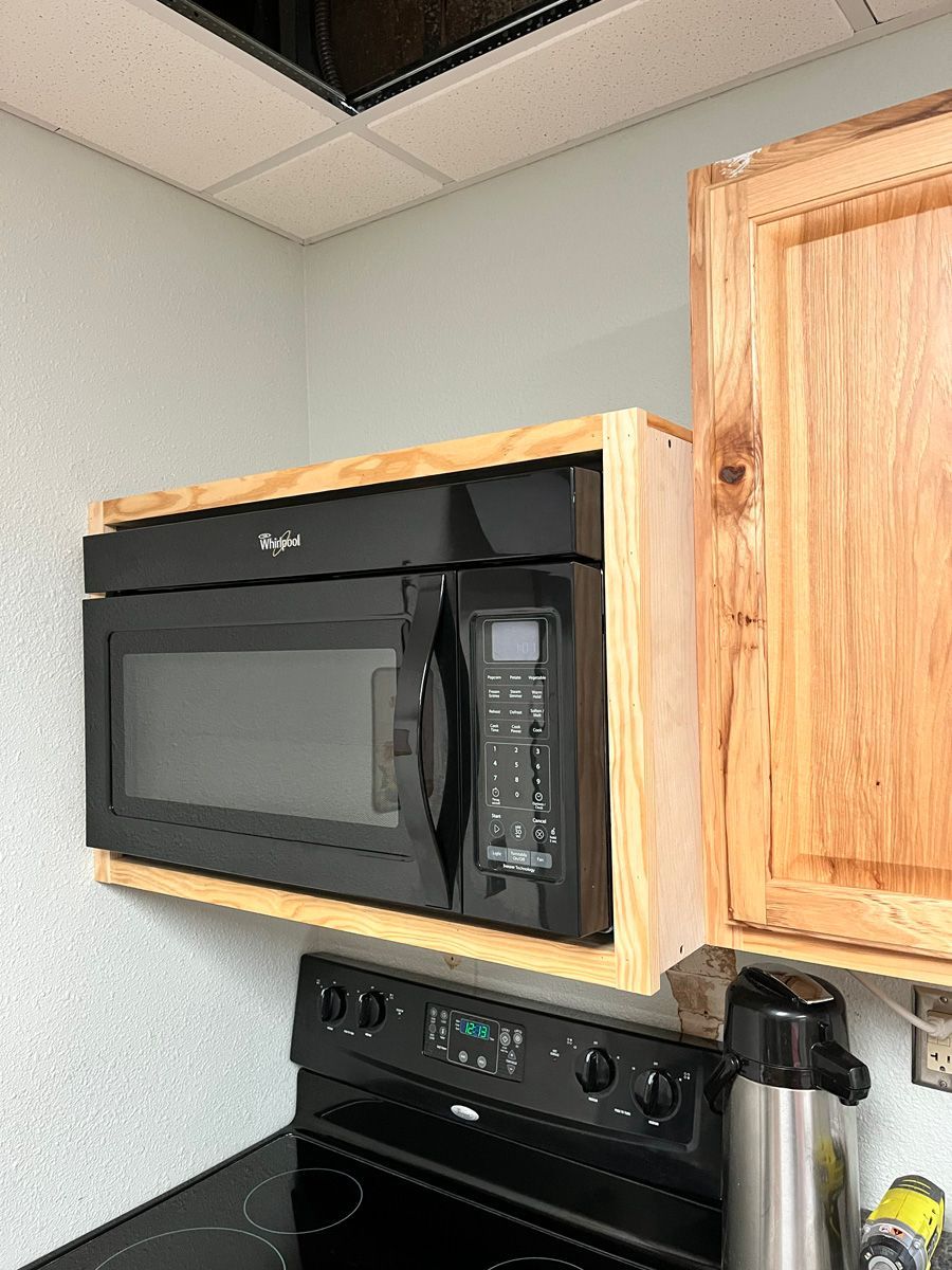 A microwave oven is sitting on top of a stove in a kitchen.