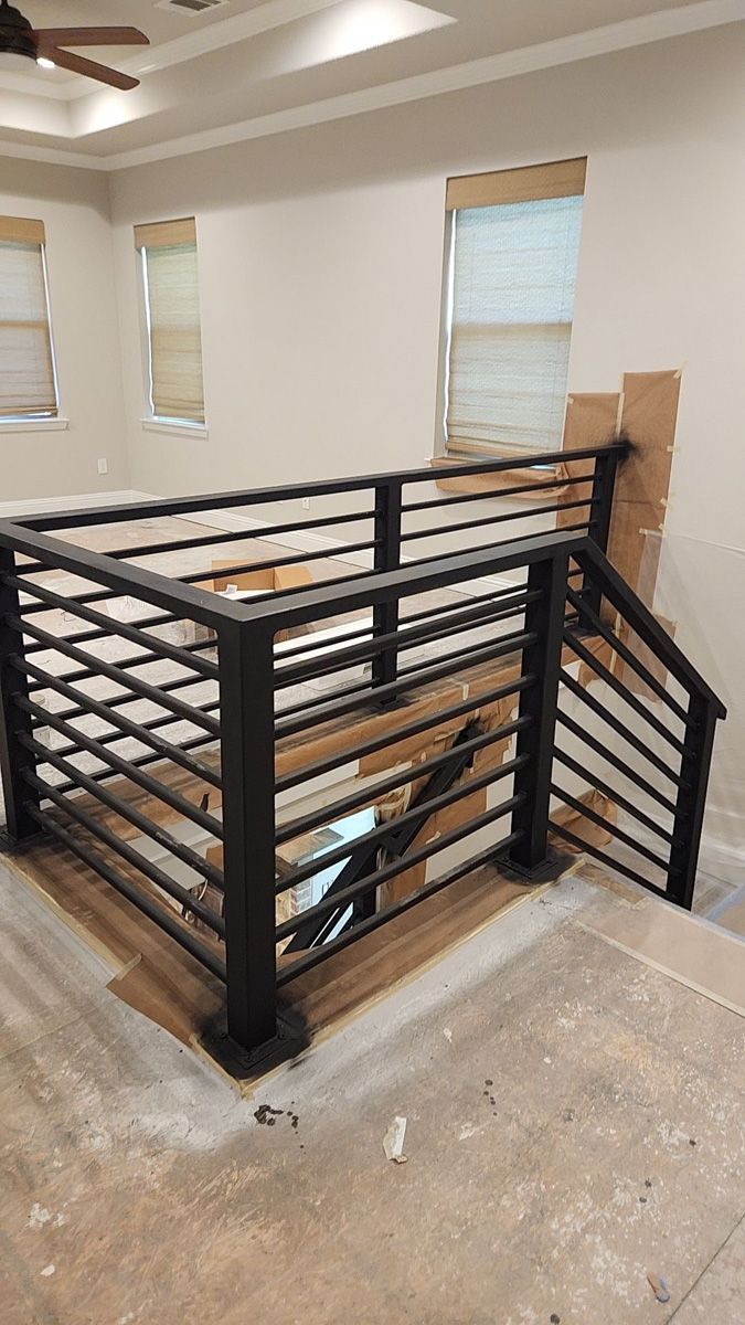 There is a staircase with a metal railing in the middle of the room.