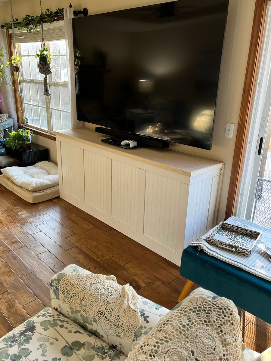 A living room with a large flat screen tv mounted on the wall.