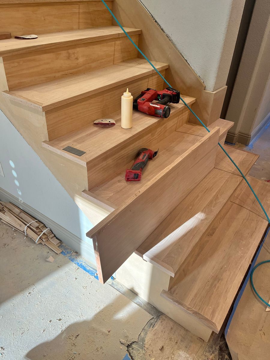 A wooden staircase is being built in a house.