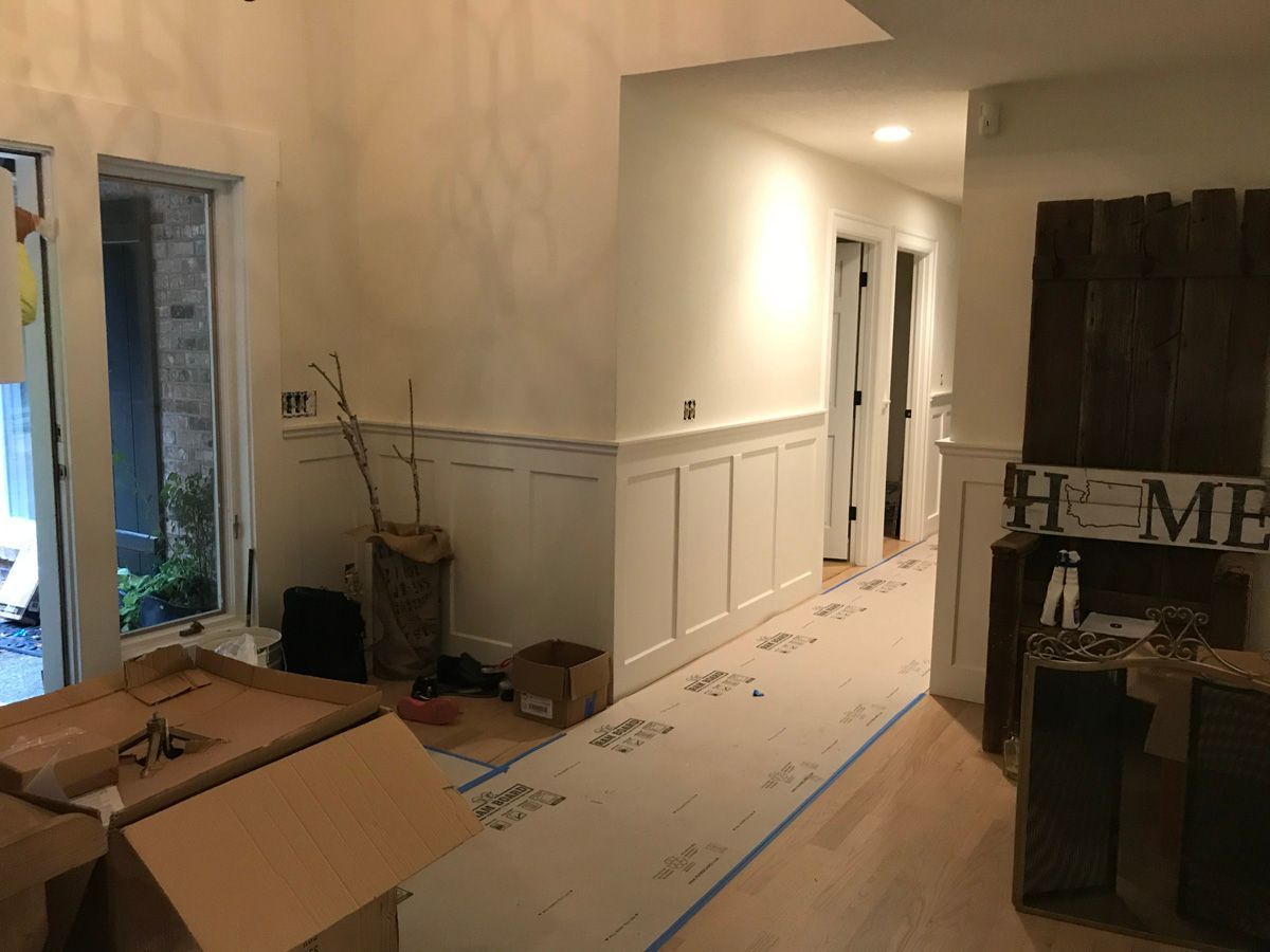 A hallway with boxes on the floor and a sign that says `` home ''.