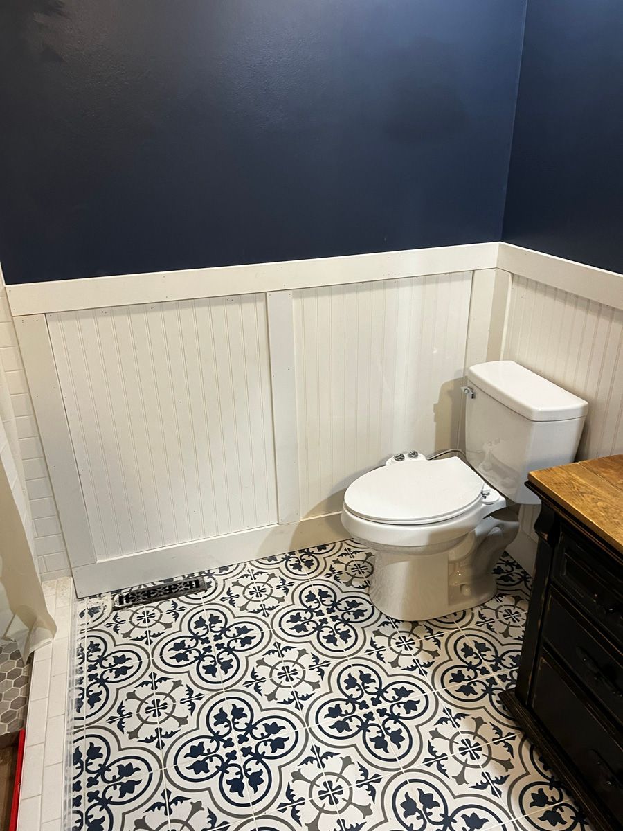 A bathroom with a toilet , sink , and blue walls.