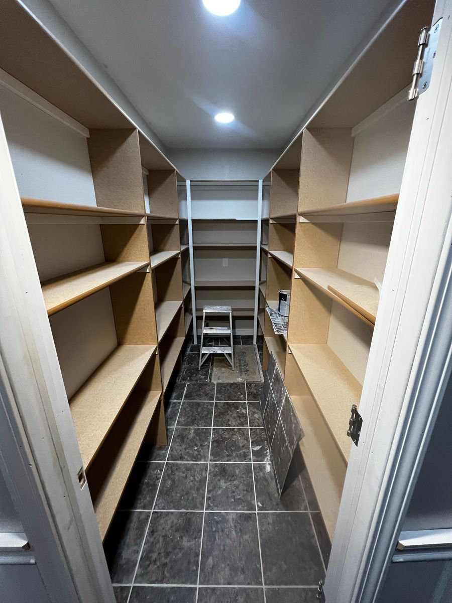 A walk in closet with lots of shelves and a ladder