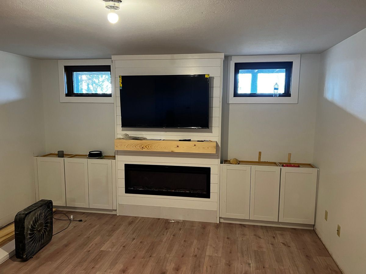 A living room with a fireplace and a flat screen tv.