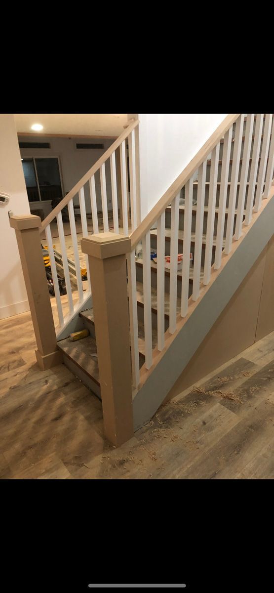 A picture of a wooden staircase with a white railing.