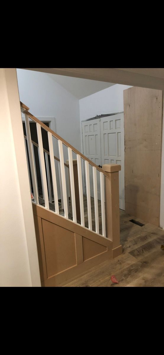 A wooden staircase with white railings in a house.