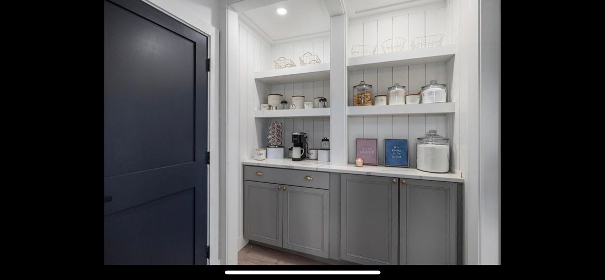 A pantry with lots of shelves and cabinets in a kitchen.