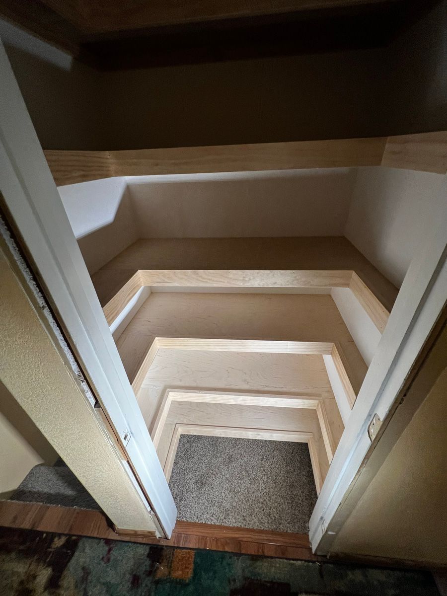 A closet with stairs leading up to the second floor.