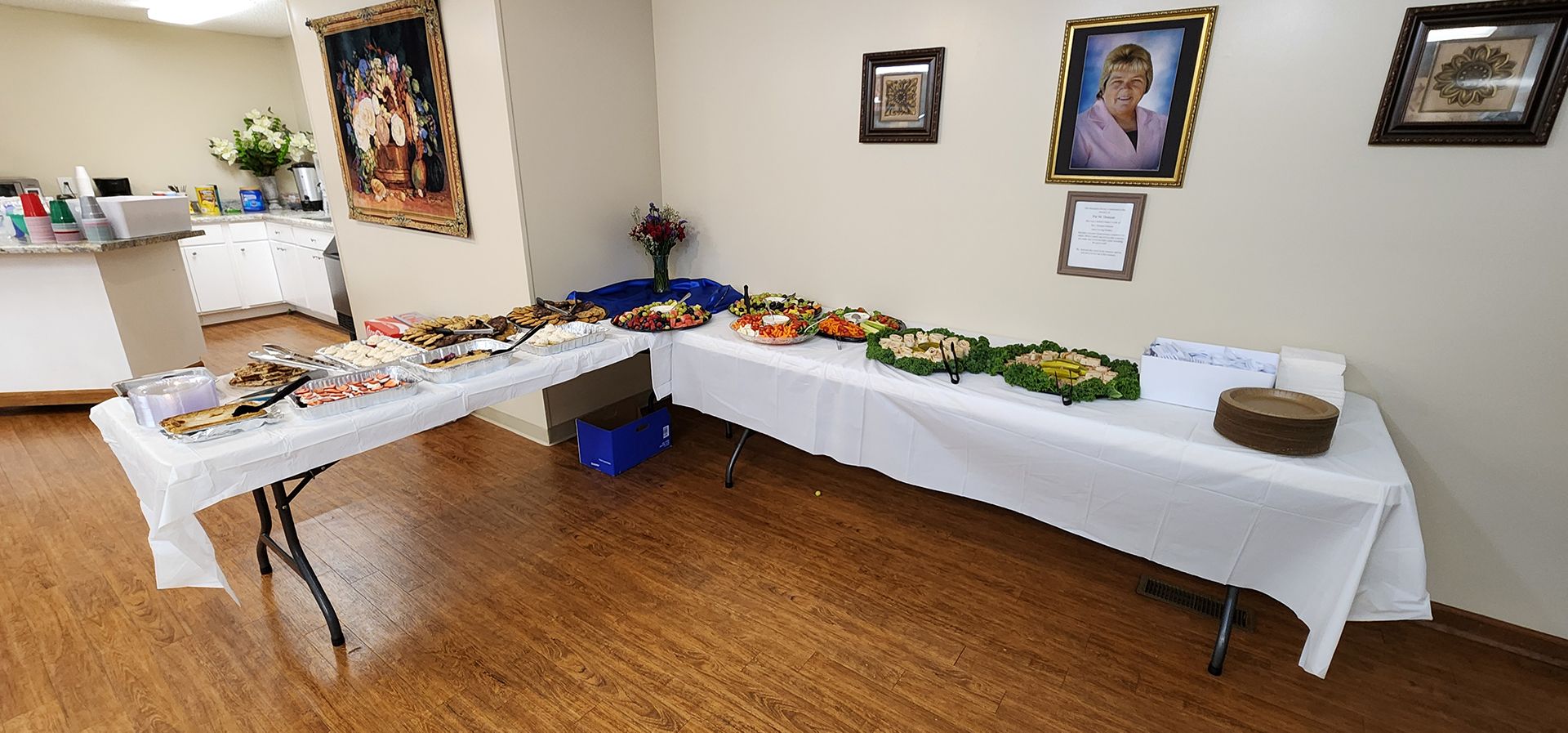 A room with two tables filled with food and pictures on the wall.