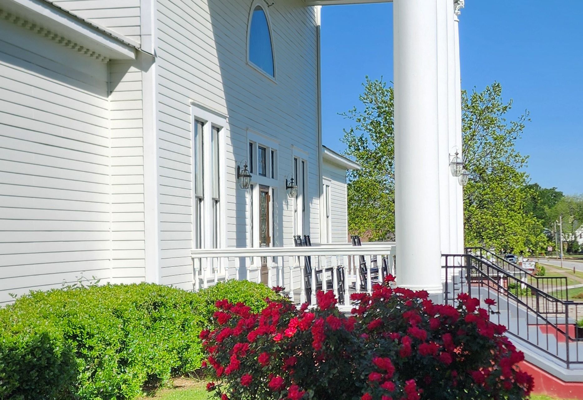 A white house with red flowers in front of it