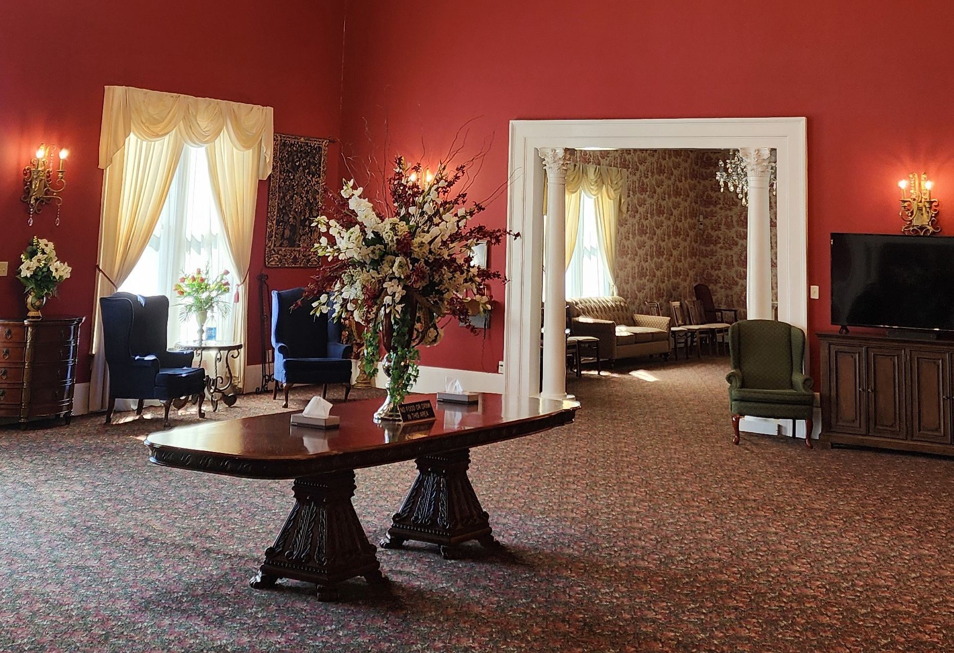 A living room with a table and chairs and a television.