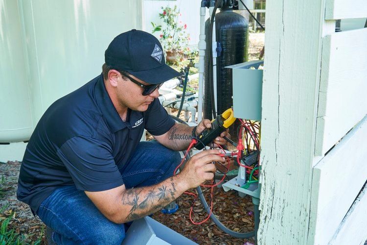 A man is working on a machine outside of a building.
