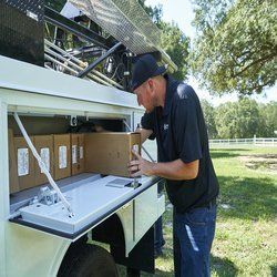 A man is loading boxes into the back of a truck.