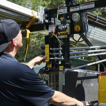 A man is working on a crane with a remote control.