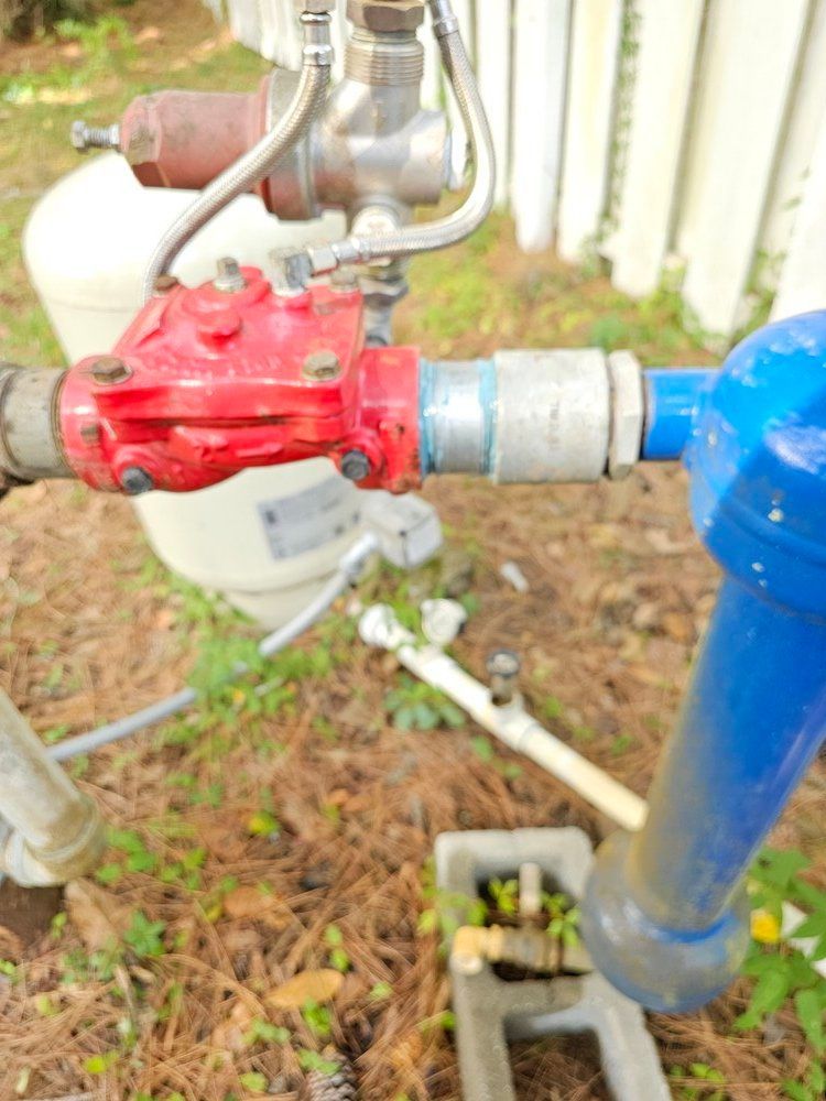 A red valve is attached to a blue pipe.
