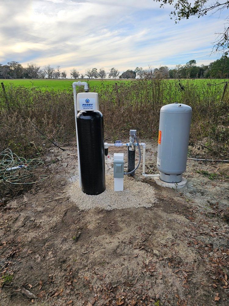 A water pump is sitting in the middle of a dirt field.