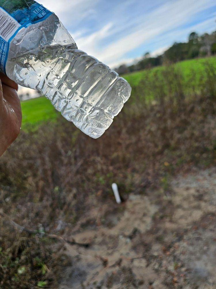 A person is holding a bottle of water in their hand.