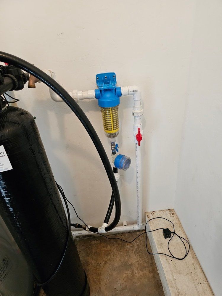 A water filter is attached to a pipe in a room.