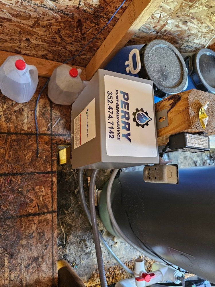 A box with a sticker on it is sitting next to a water tank.