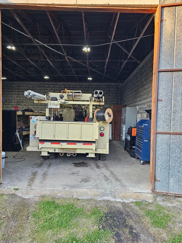 A truck is parked in a garage with the door open.