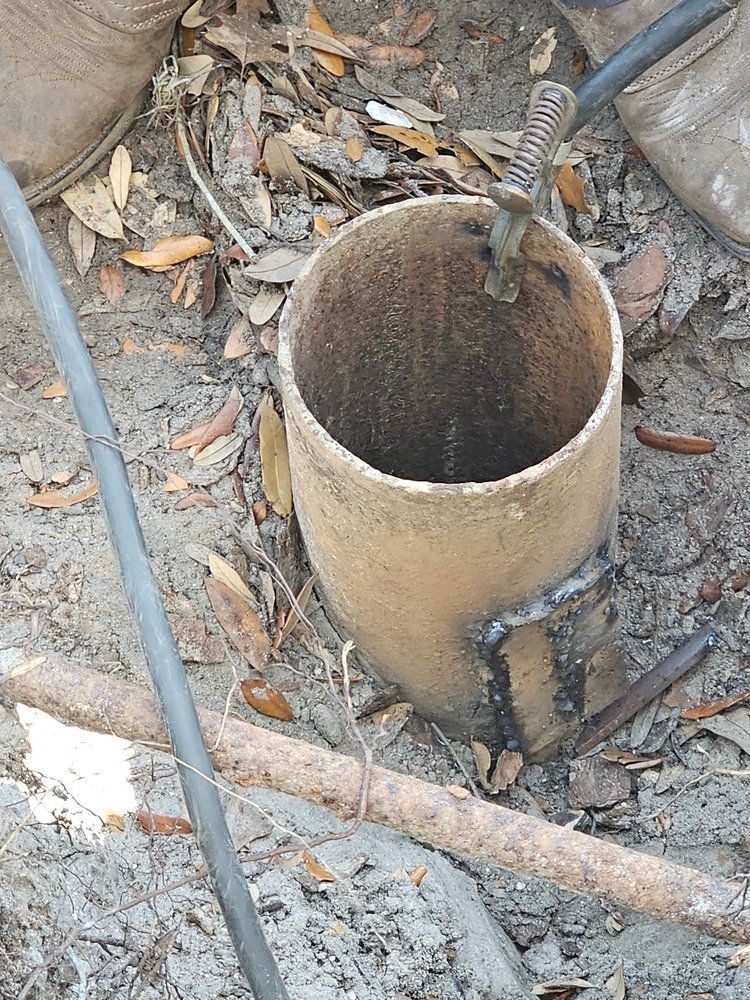 A person is using a tool to dig a hole in the ground.
