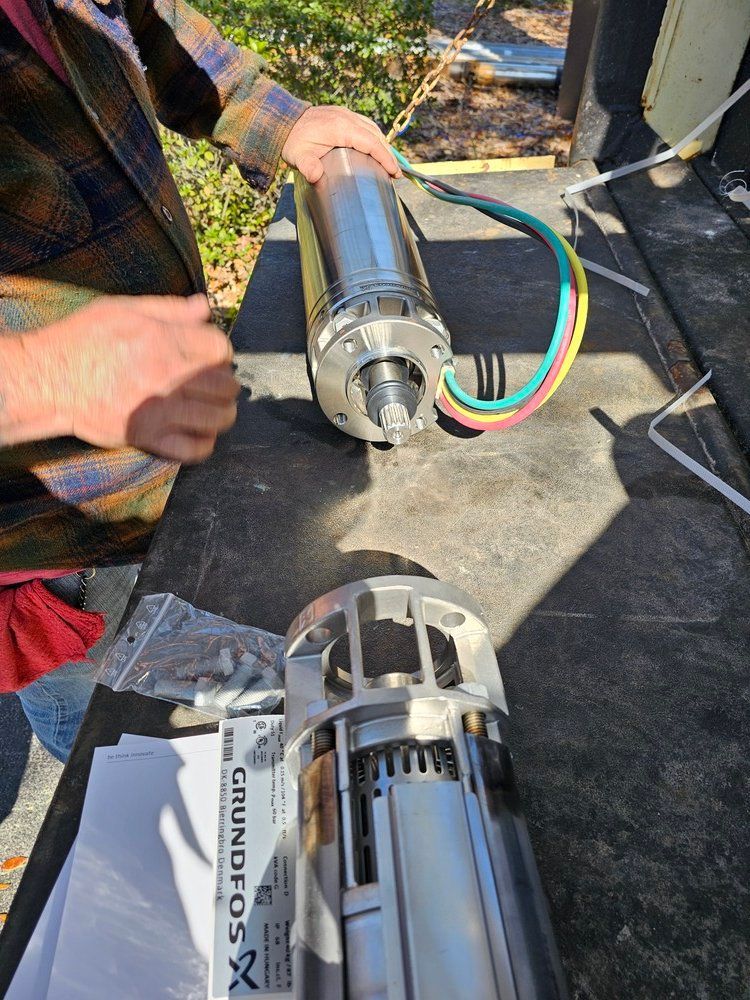 A man is working on a water pump on a table.