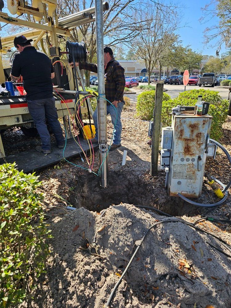 A group of men are working on a pole in the dirt.