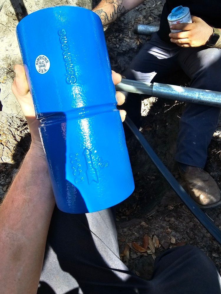 A person is holding a blue pipe that says ' stainless steel ' on it