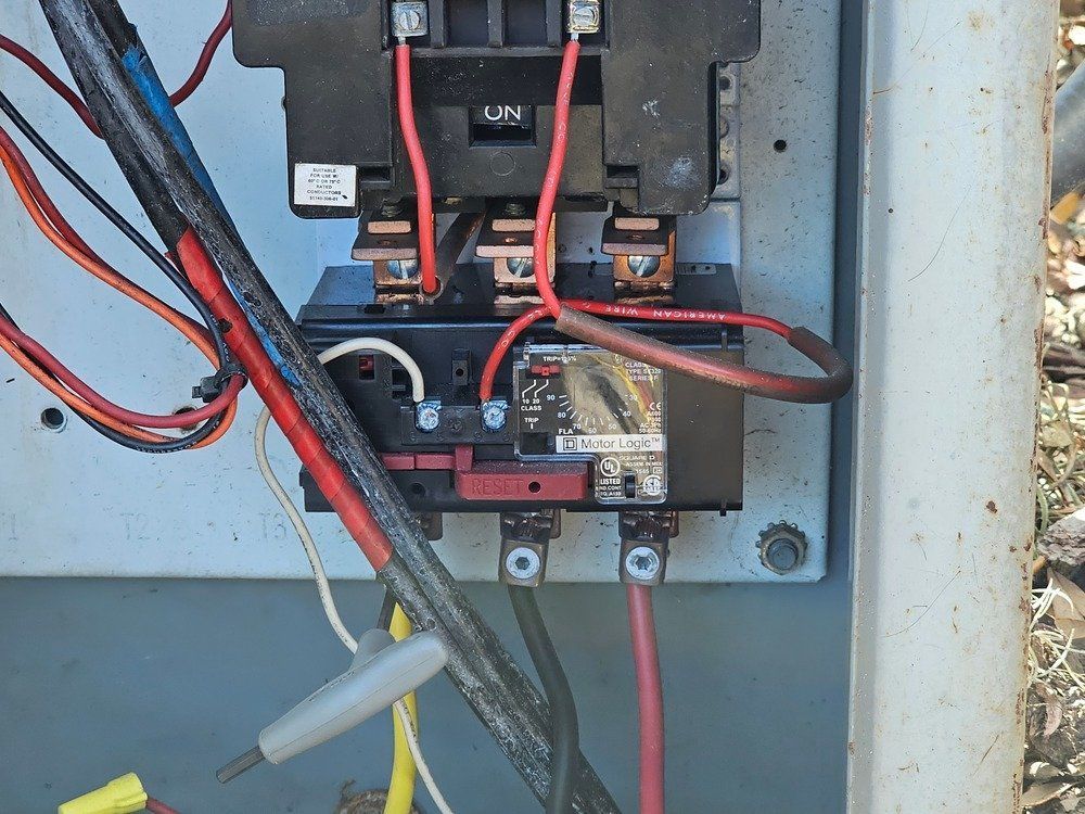 A close up of a electrical box with wires coming out of it