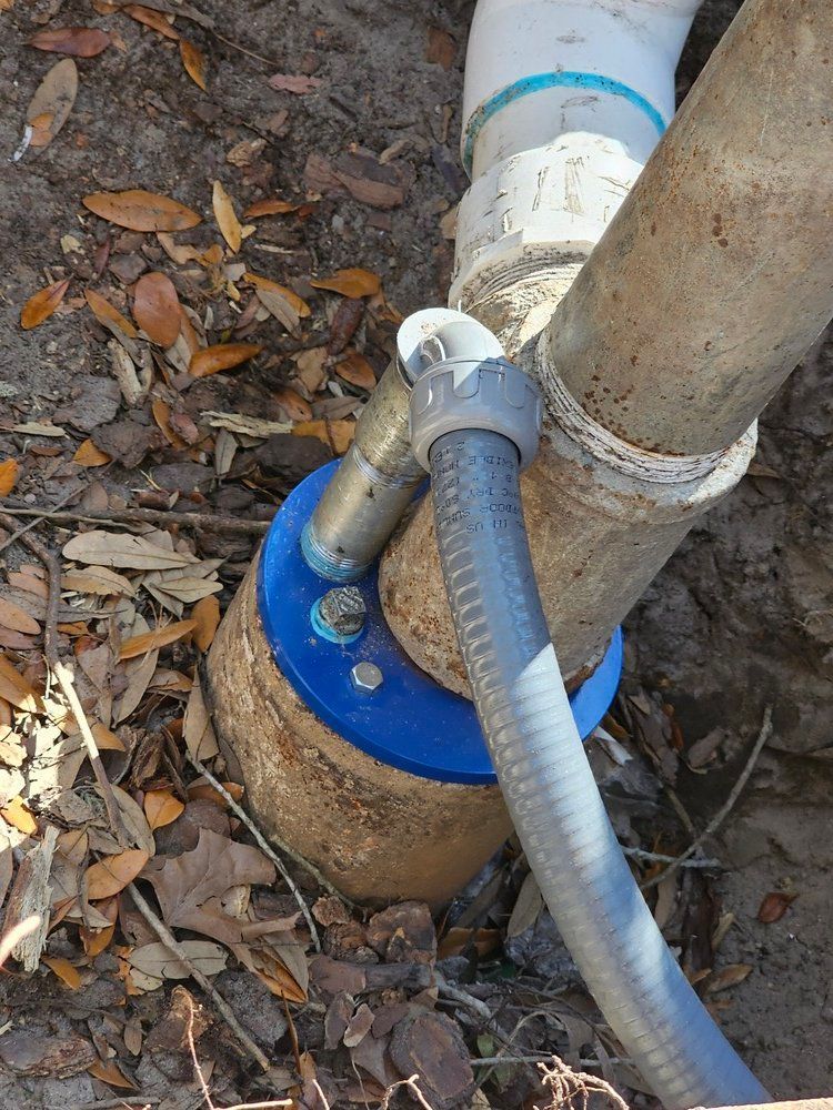 A hose is attached to a pipe in the dirt