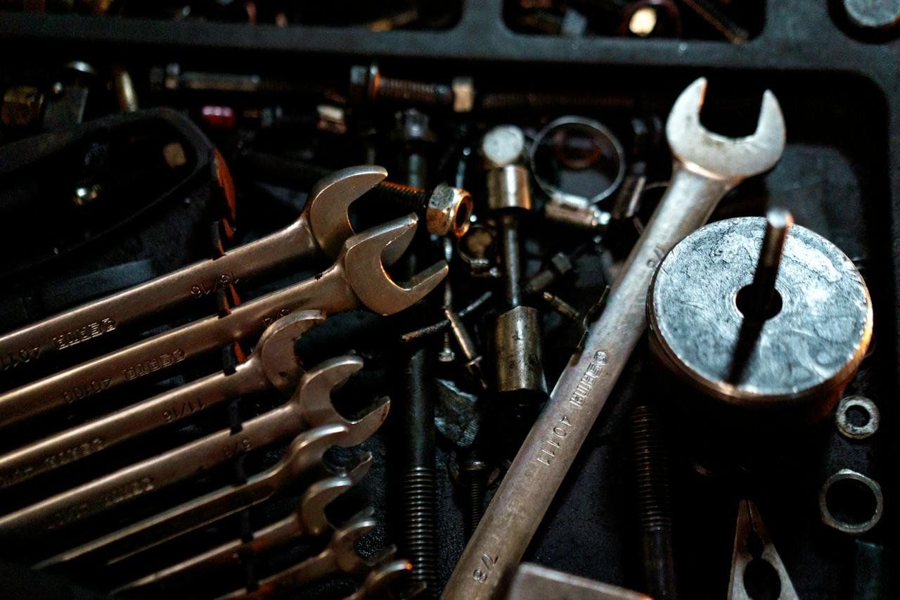 A bunch of wrenches are sitting on top of each other on a table.