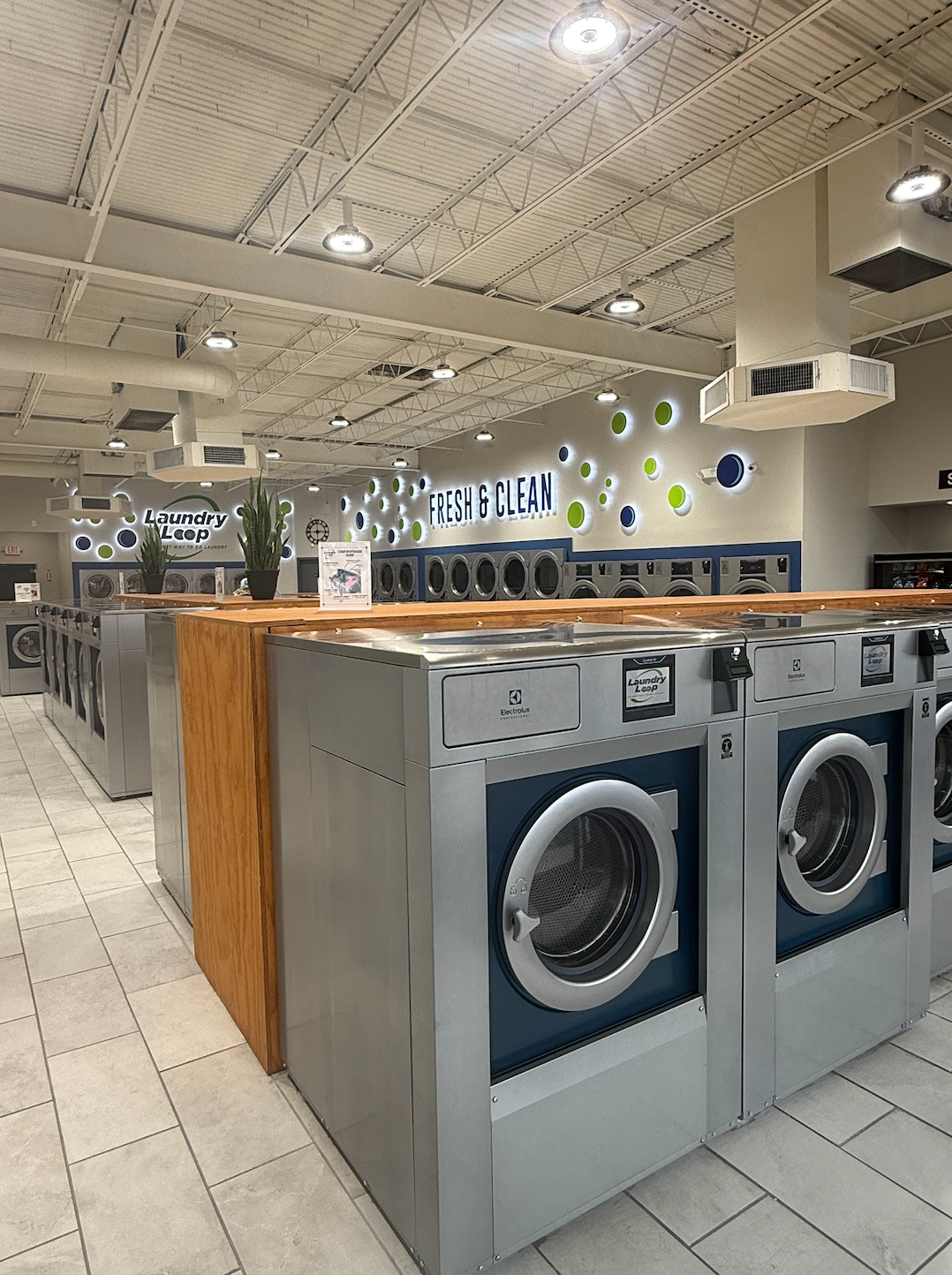 Laundry Loop washateria with industrial washing machines and Laundry Loop signage on the display