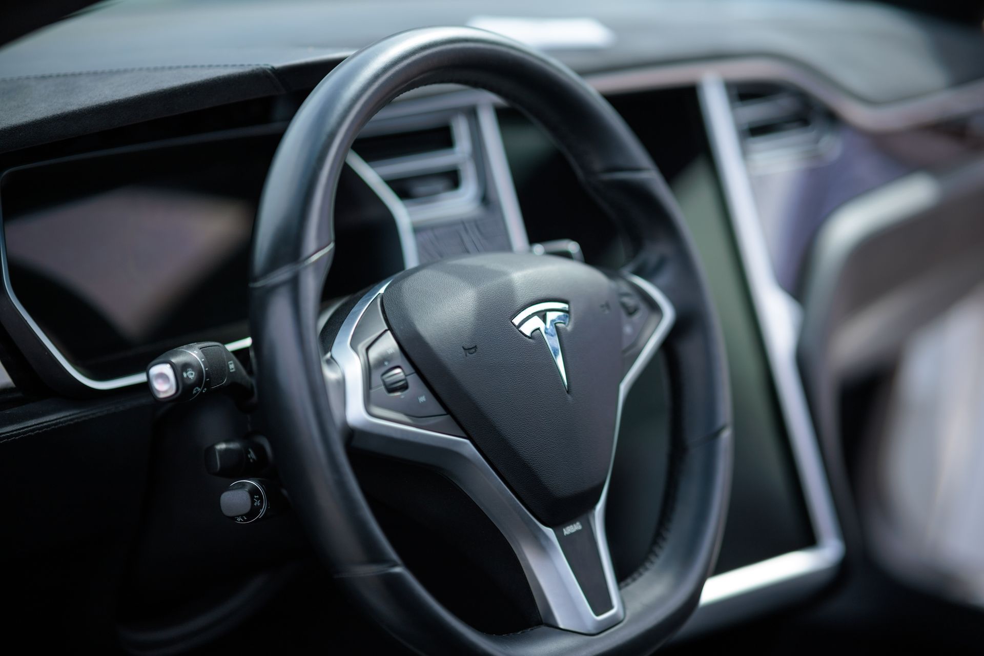 Interior view of a beige and brown Mercedes-Benz G-Class SUV, chrome and wood accents, snowy exterior.