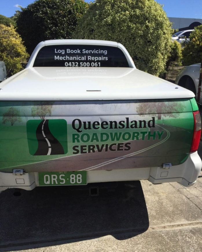 A Queensland Roadworthy Services Truck is Parked on the Side of the Road — Queensland Roadworthy Services In Southport, QLD